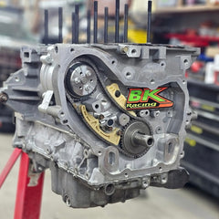 Automotive engine block assembly showing timing chain, sprockets, and BK Racing logo.