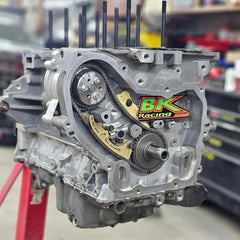 Automotive engine block assembly showing timing chain, sprockets, and BK Racing logo.